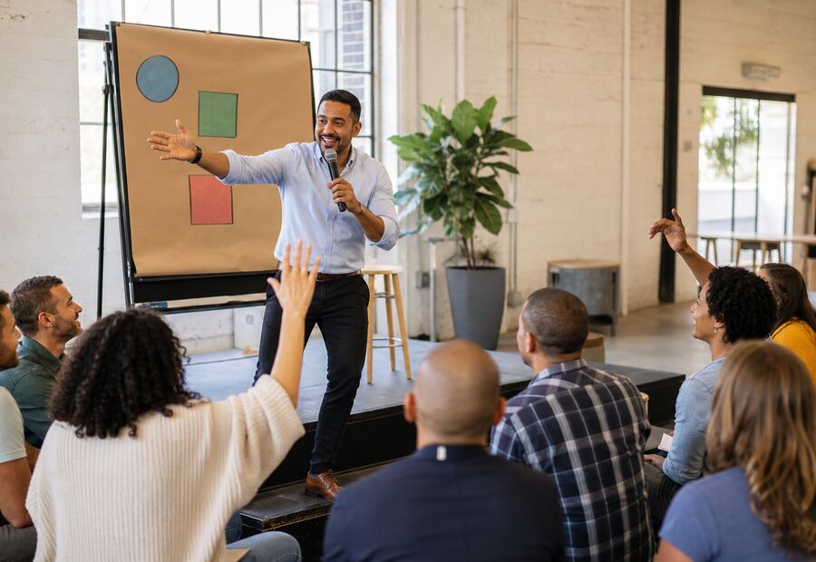 A facilitator working with a seated group in a bright room